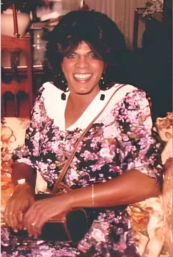A photo of Roberta Angela Dee, a well-dressed middle-aged black woman with a nicely composed 20th century hairdo and a dress with roses and a white lacy collar